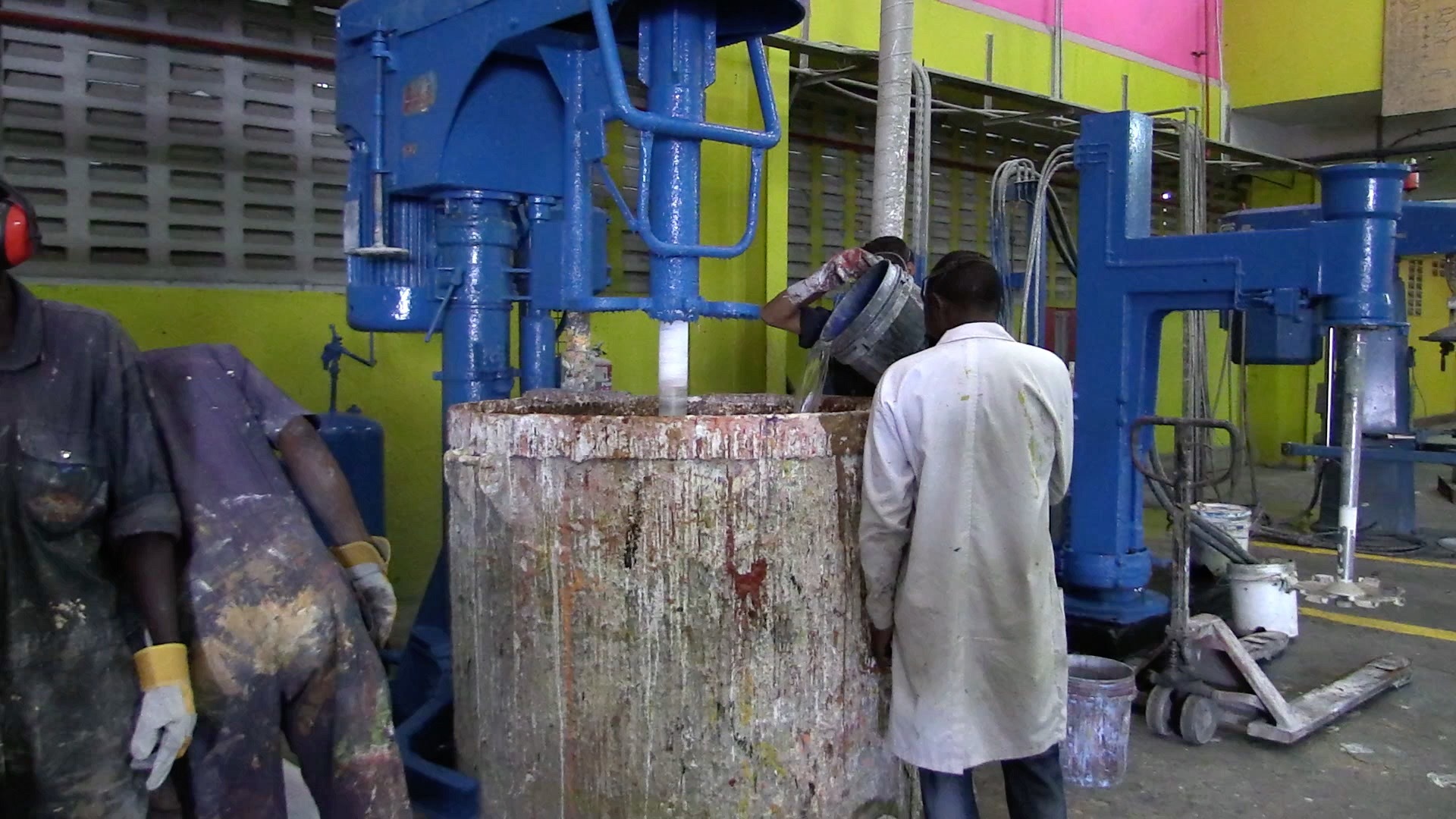 A worker is keeping an eye on the mixing of paint in a paint factory