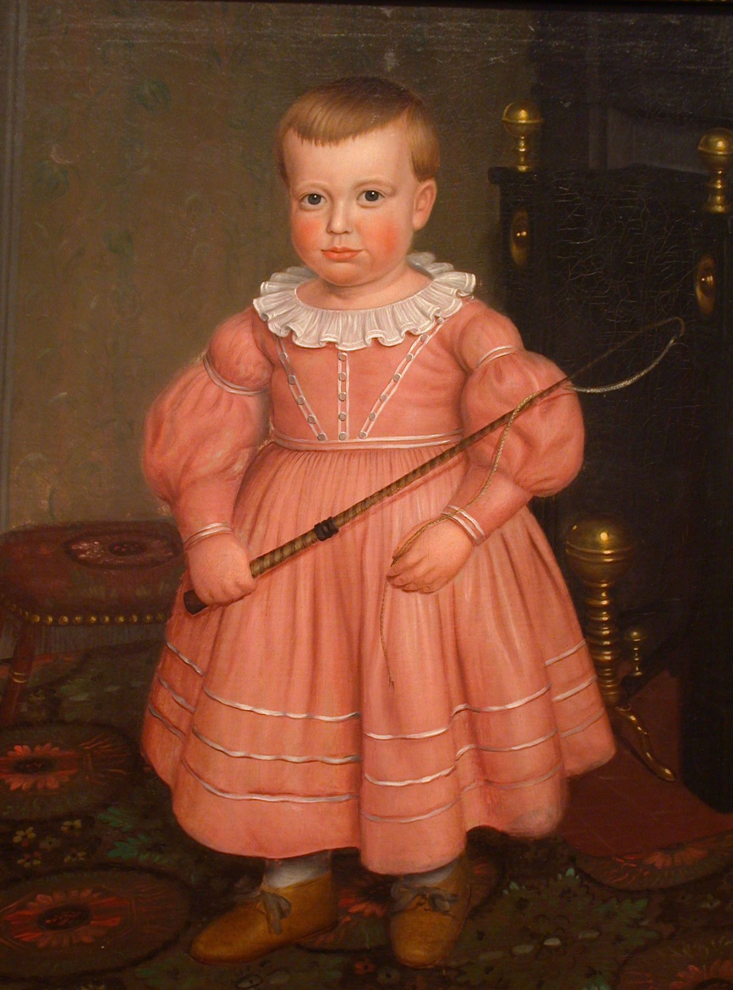 ‘Young Boy with Whip’ circa 1840, Anonymous American School Painting, Honolulu Museum of Art, Copyright: Public Domain – US. A seventeenth century portrait of a small boy, holding a whip. He is wearing a pink dress