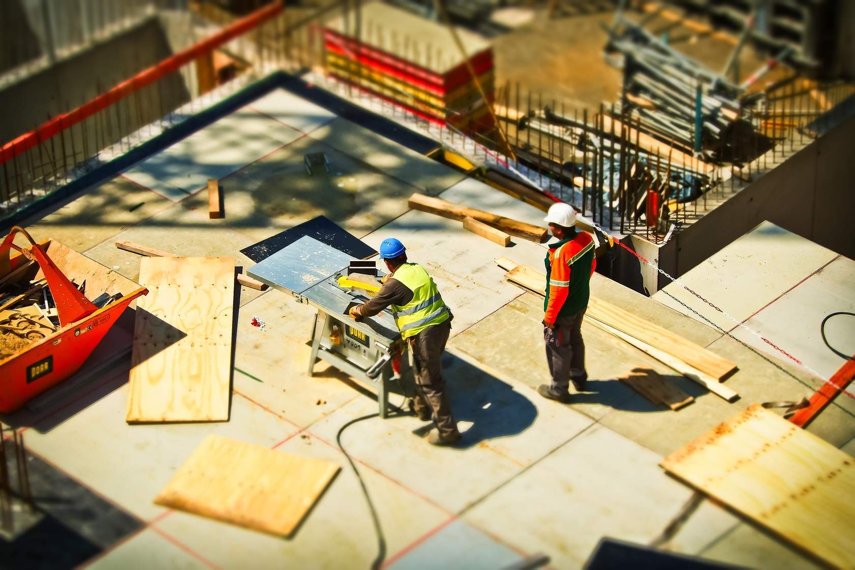 Construction field. With two men, number 1 is working on a table and number 2 is looking at the site