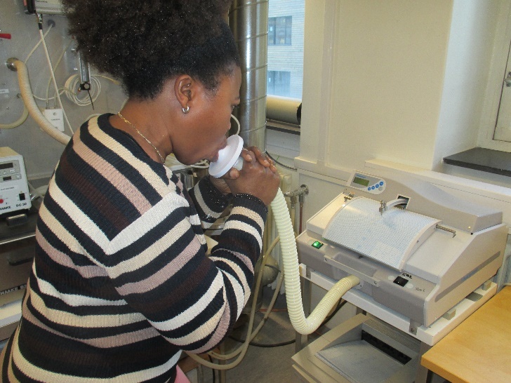 Spirometry examination is performed. A worker blows into the apparatus to measure her lung funcion.