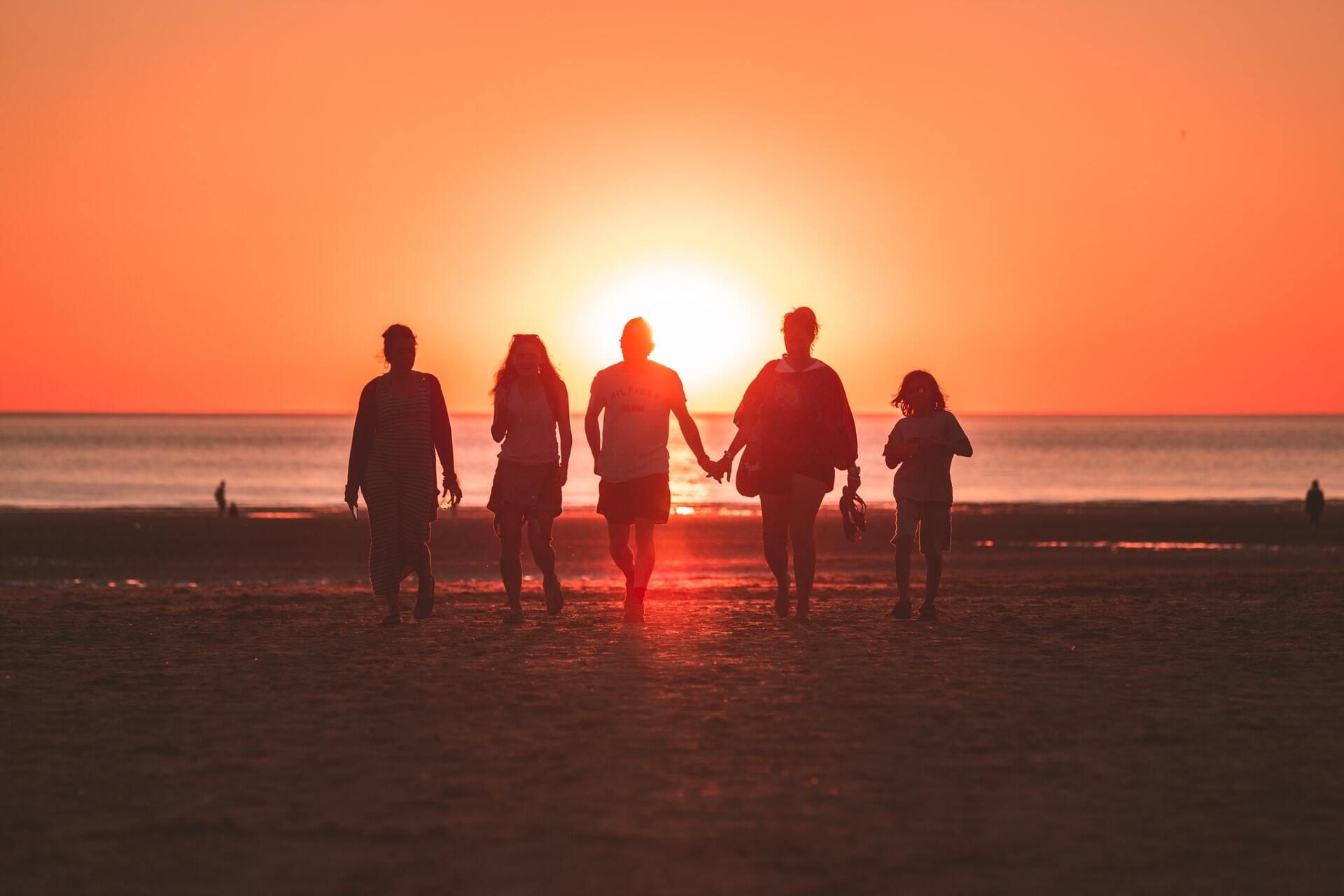 A family together on a beach at sunset.