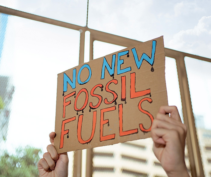 Protestor holding "No New Fossil Fuels" sign.