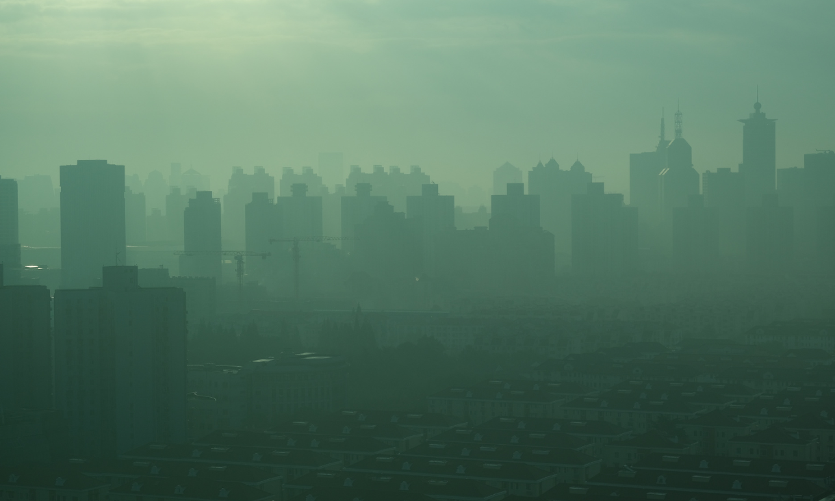 Wideshot of a smog-filled cityscape.