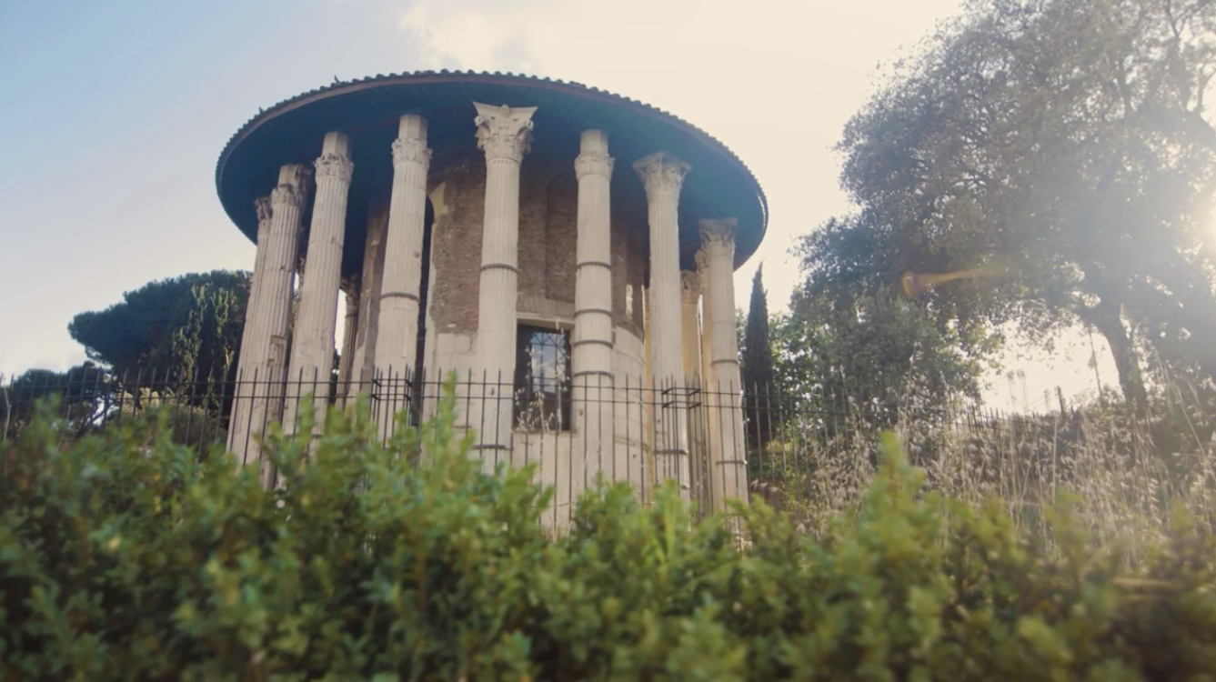A photo of a stone round temple surrounding by trees