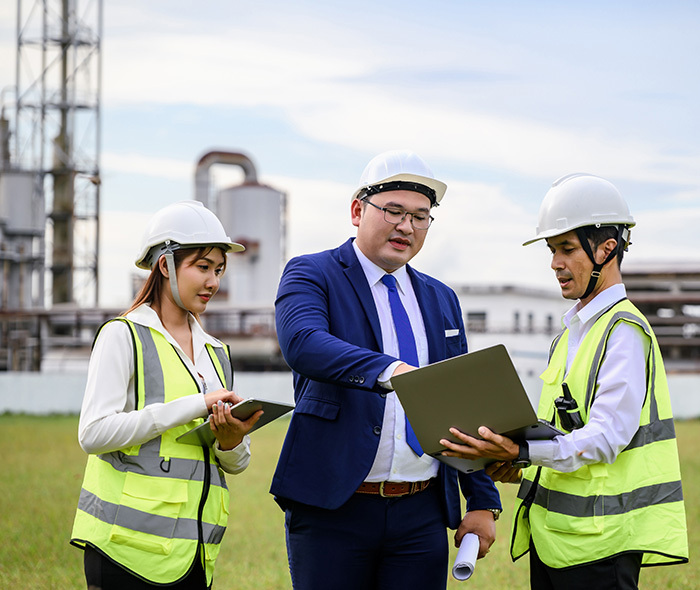 Workers at a powerplant looking at a computer.