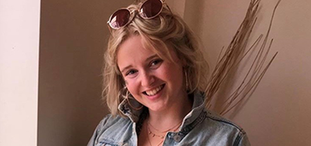A portrait of a young woman with shoulder length blond hair