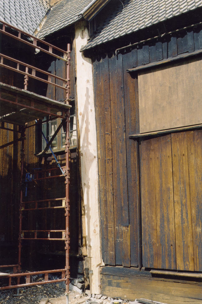 A picture of a replaced post seen from outside a Stave Church.