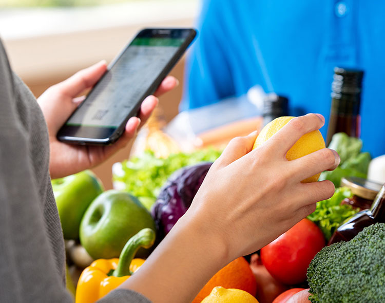 Close up of somebody checking fruit and veg delivery on an app.