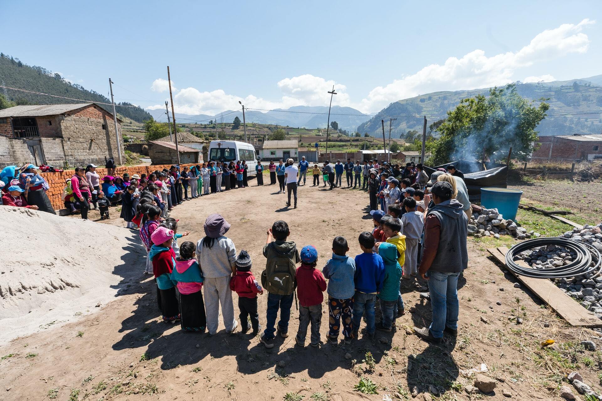 A community gathered in a circle outdoors.