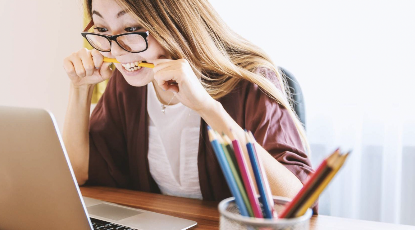 a woman at a desk rubbing her eyes