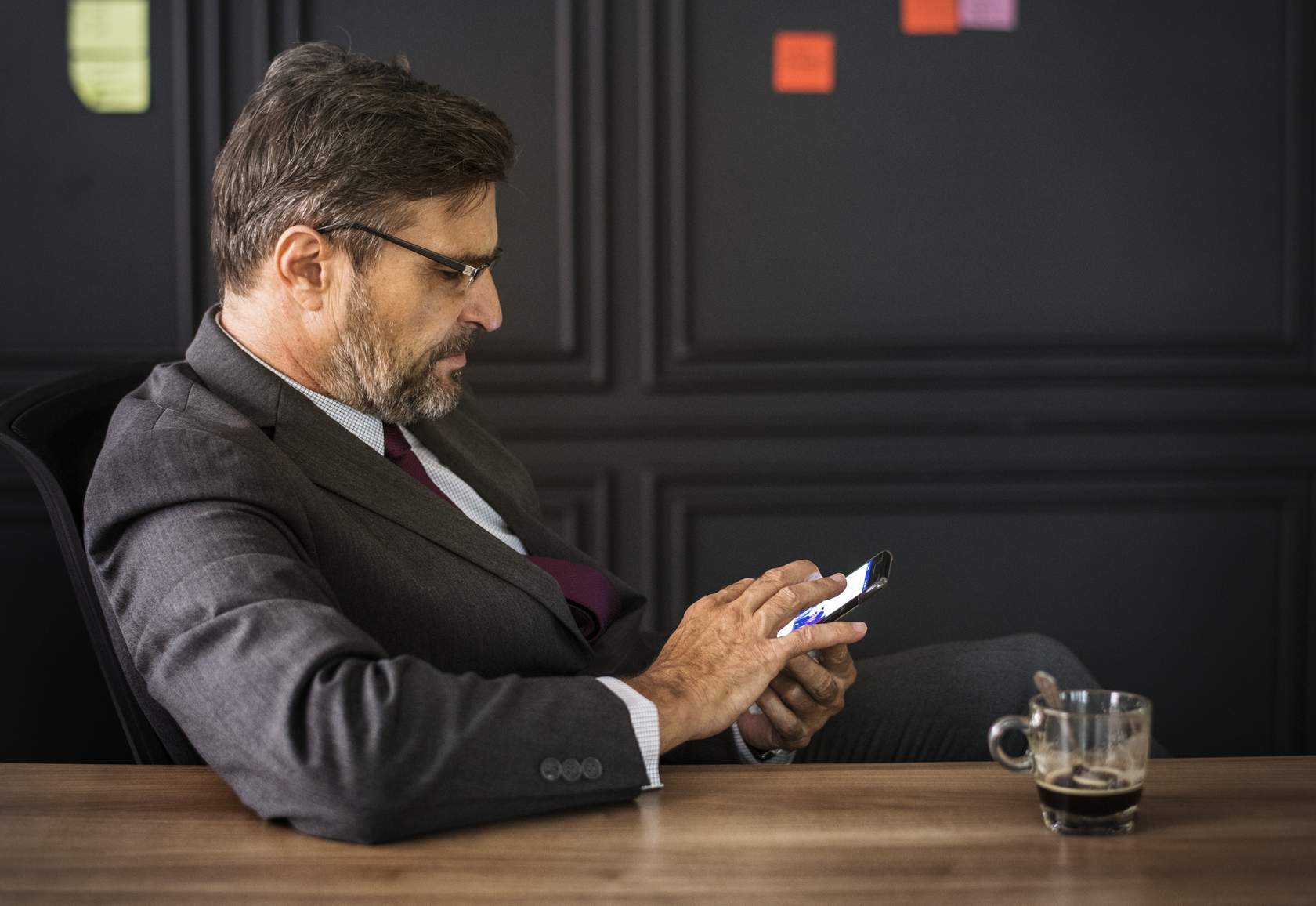 Bearded man types on a mobile phone