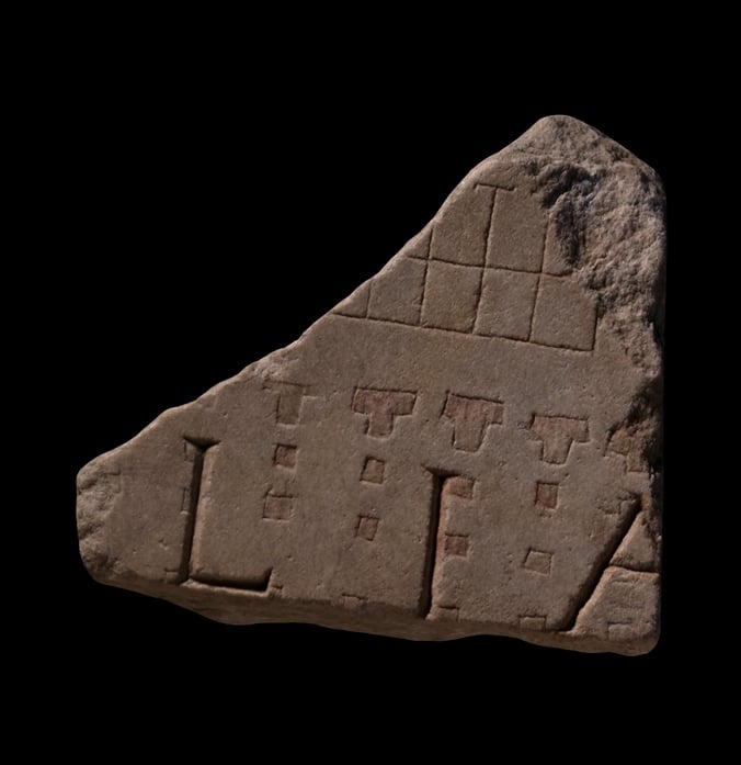 A piece of a marble map with carvings