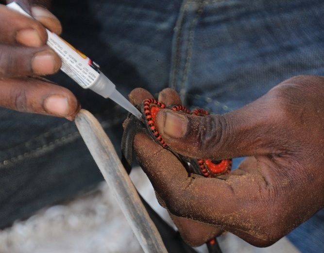 shoemaker mending shoe with glue