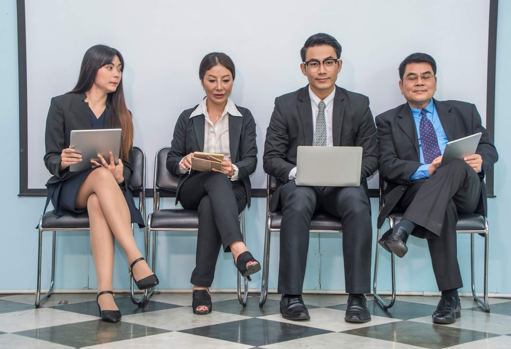 four people in professional suits sitting next to each-other