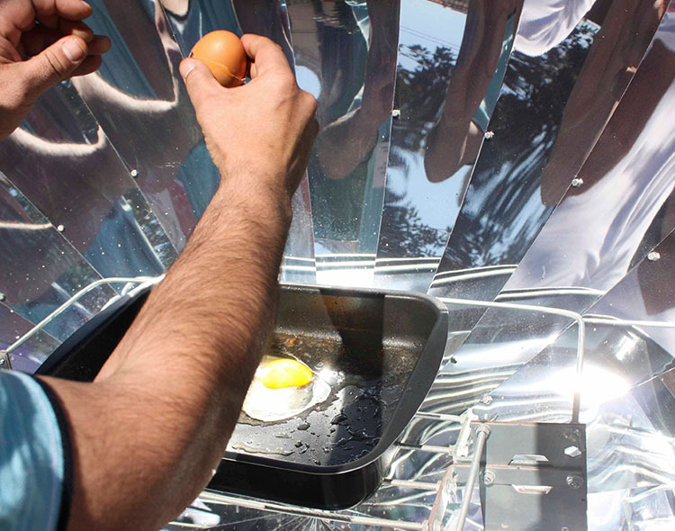 An egg being fried in a solar oven.