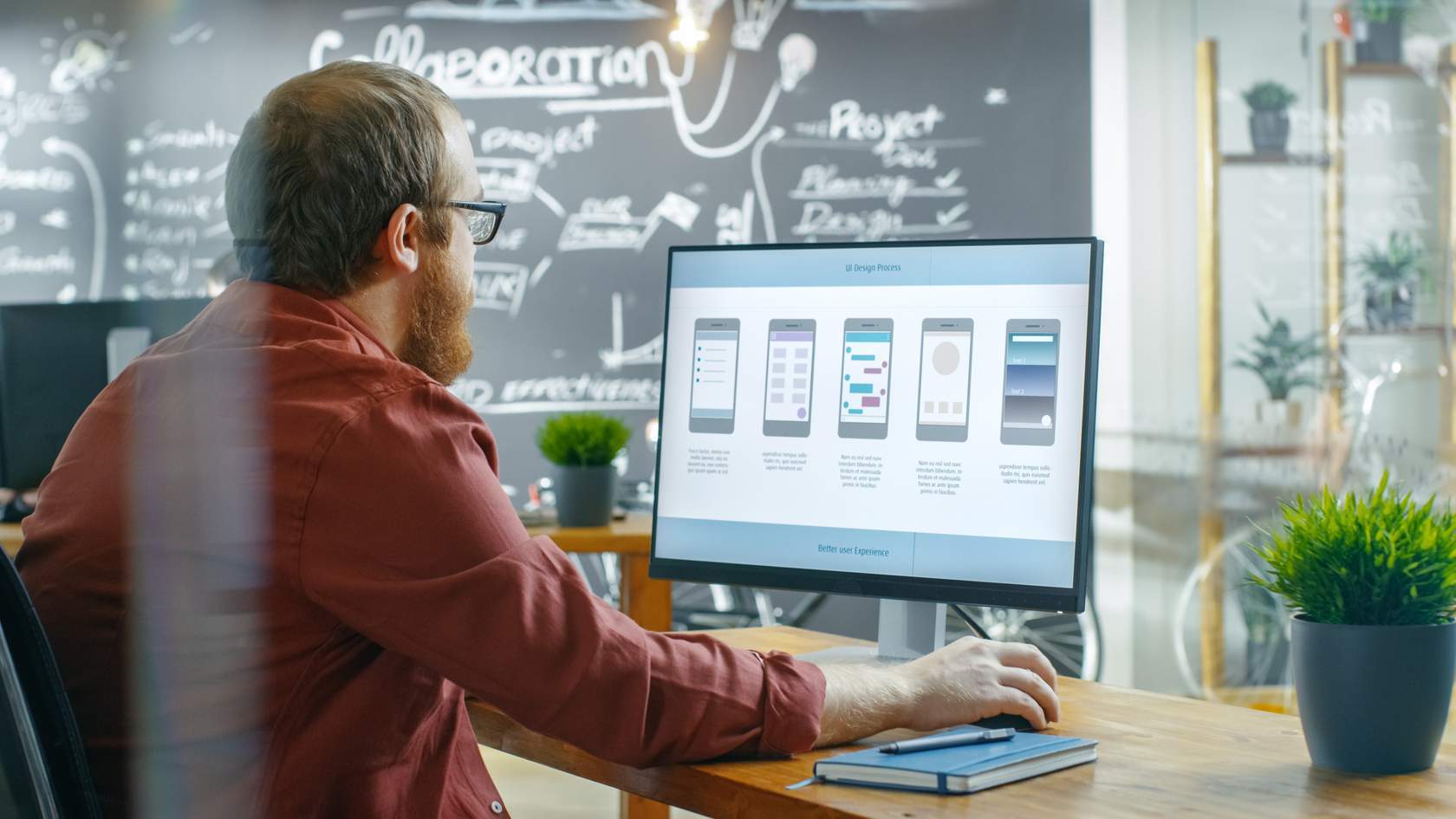 Men looking at a computer screen. In the screen you can see mobile phones with different displays