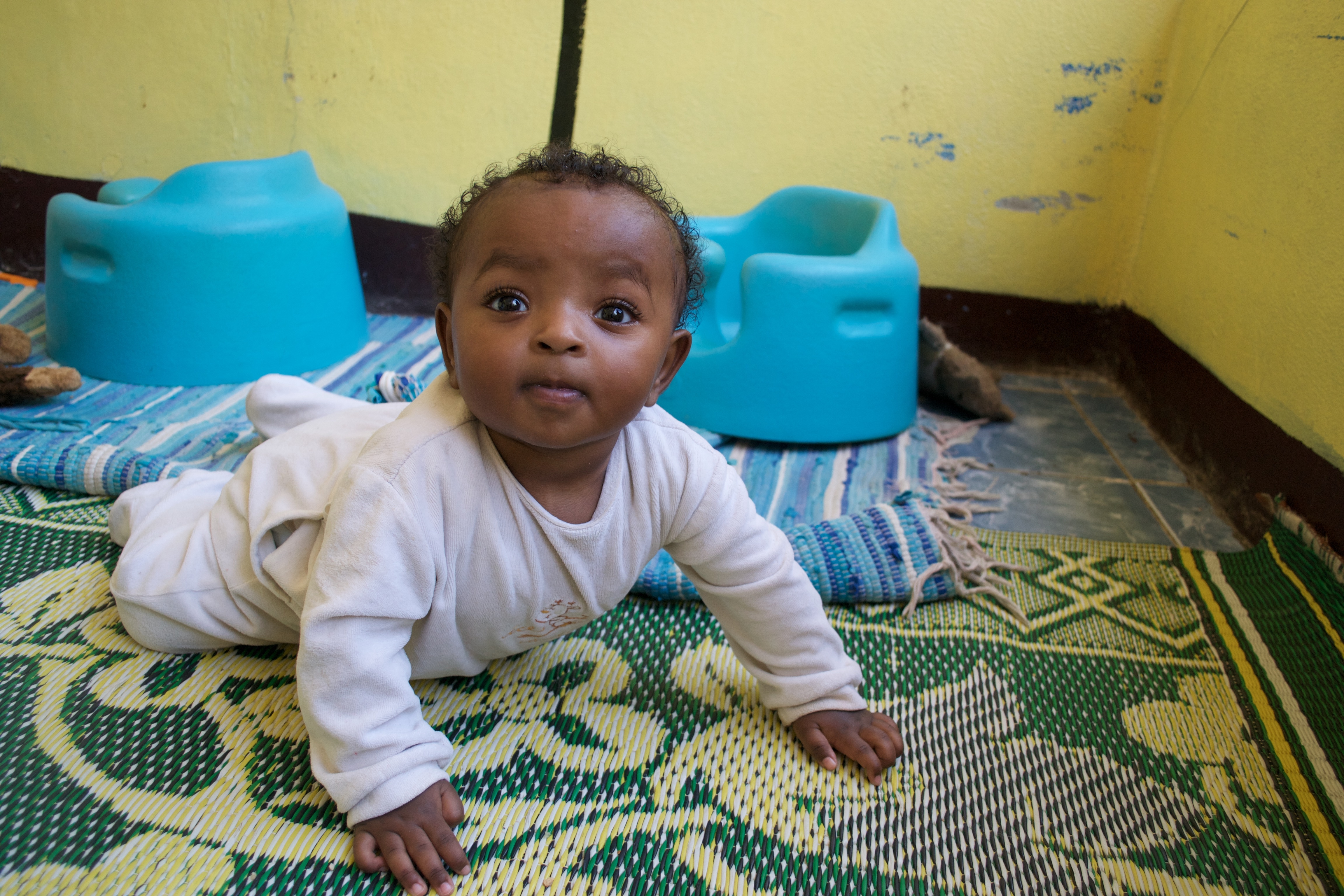 A young child in a crawling position on the floor