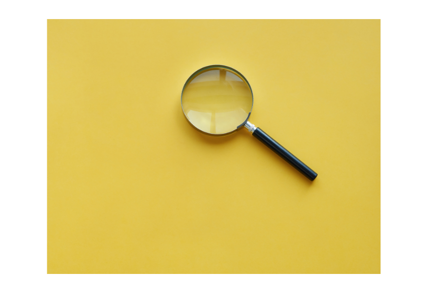 Magnifying glass against yellow background.