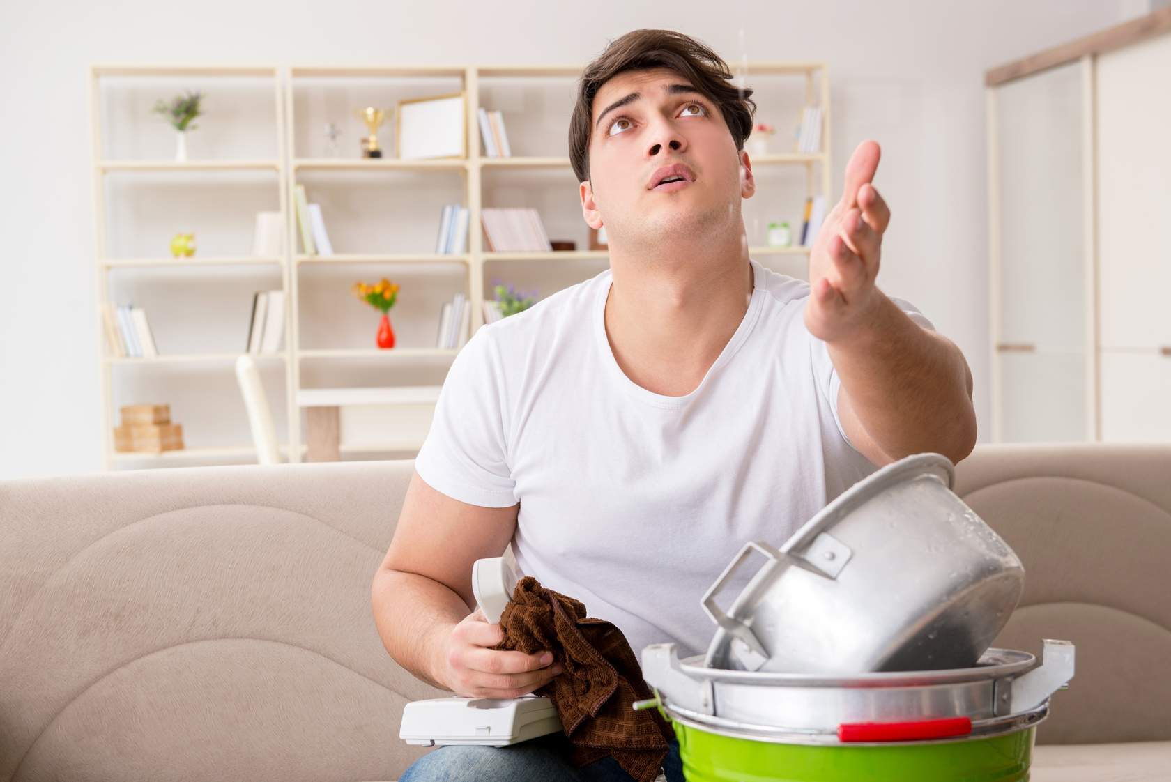 Man looks up and holds out hand to check if water is still dripping