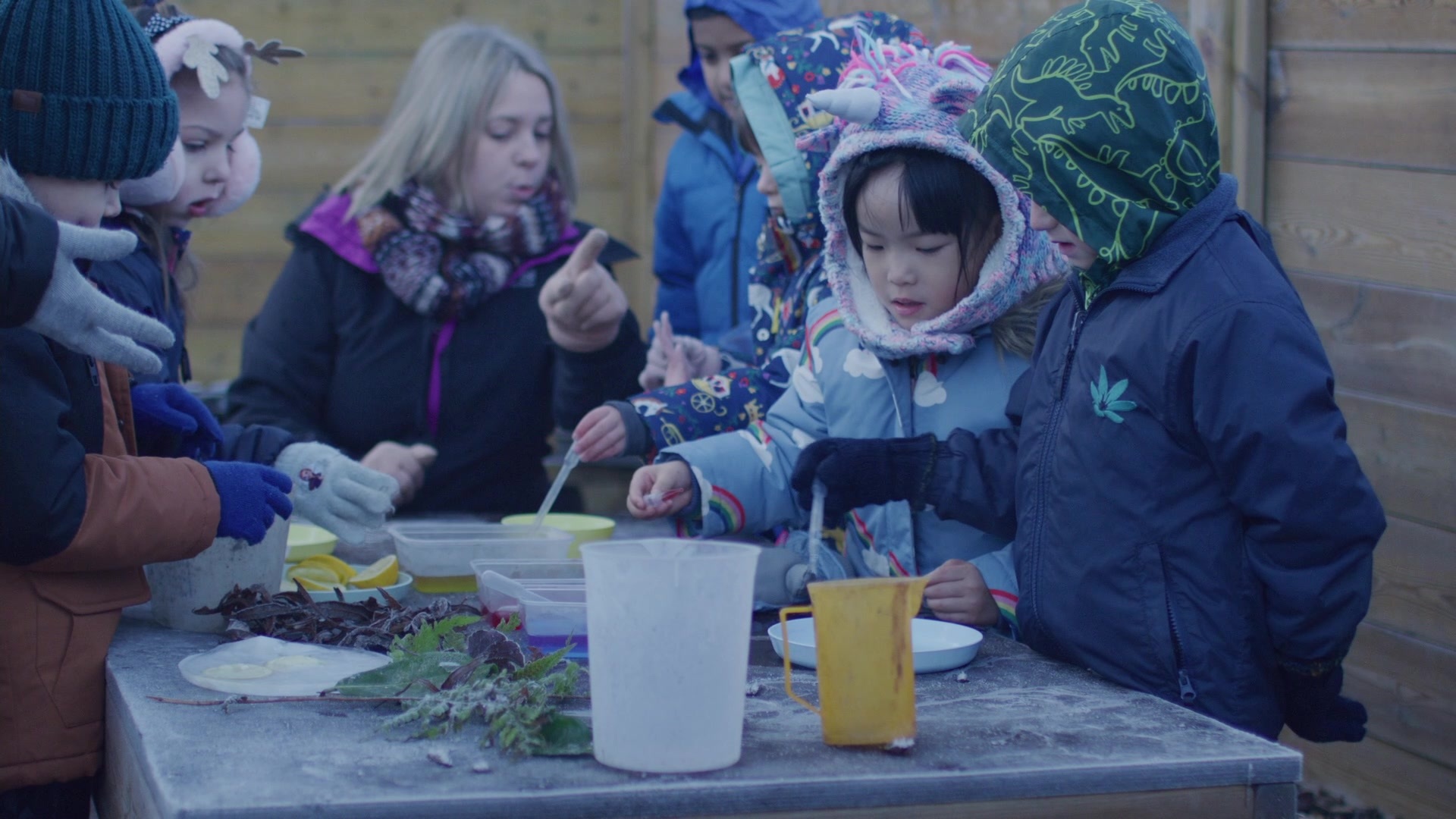 Children using pipettes and measuring jugs outside