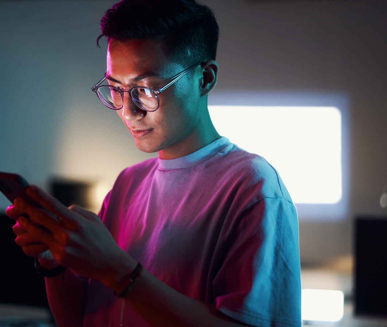 Man with glasses looking at phone