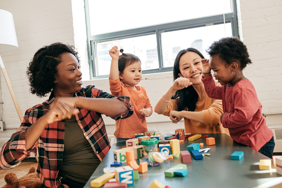 diverse children and teachers playing at pre school