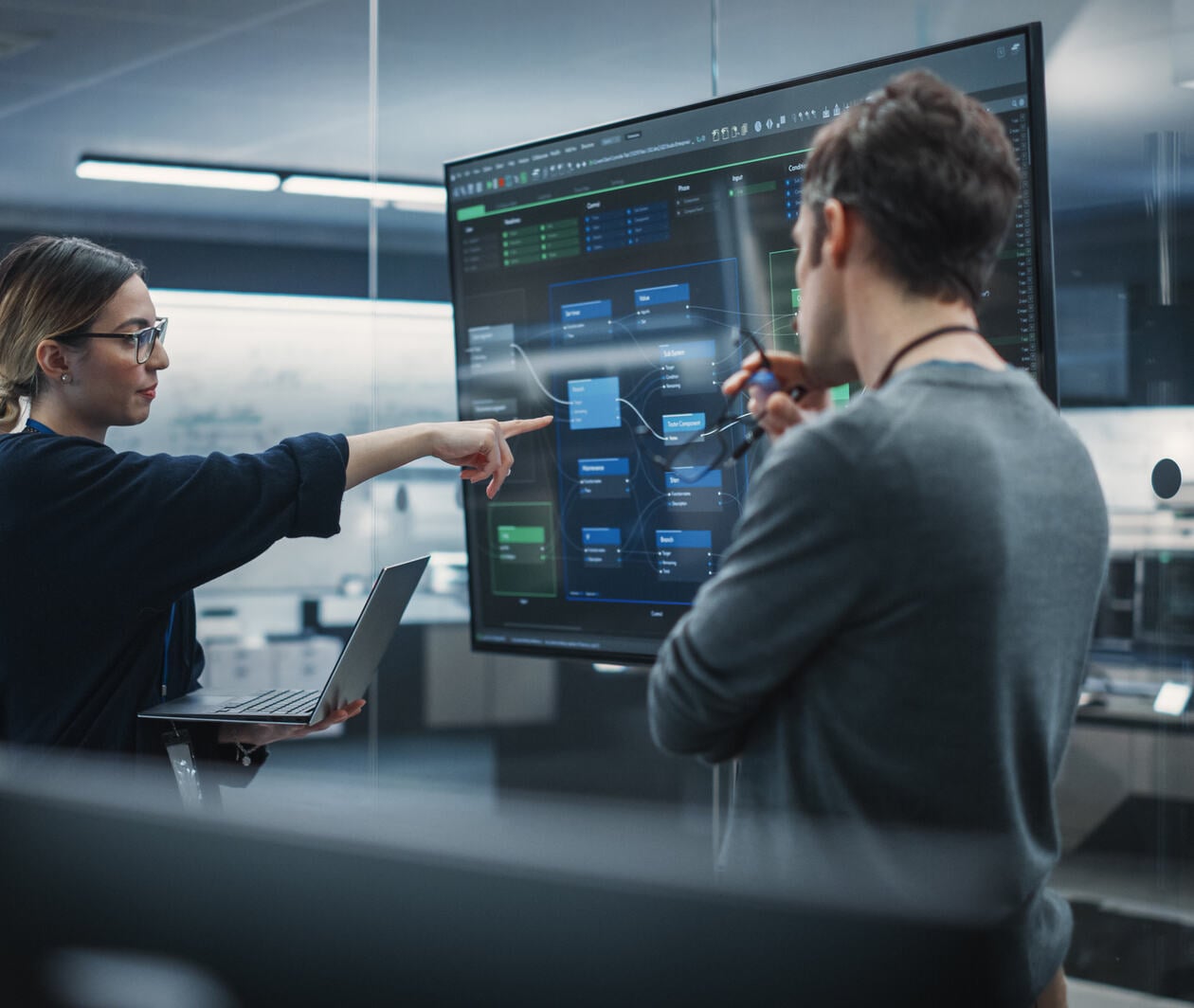 Two Diverse Software Developers Having a Meeting in a Conference Room. Female and Male Tech Industry Engineers Brainstorming Ideas.