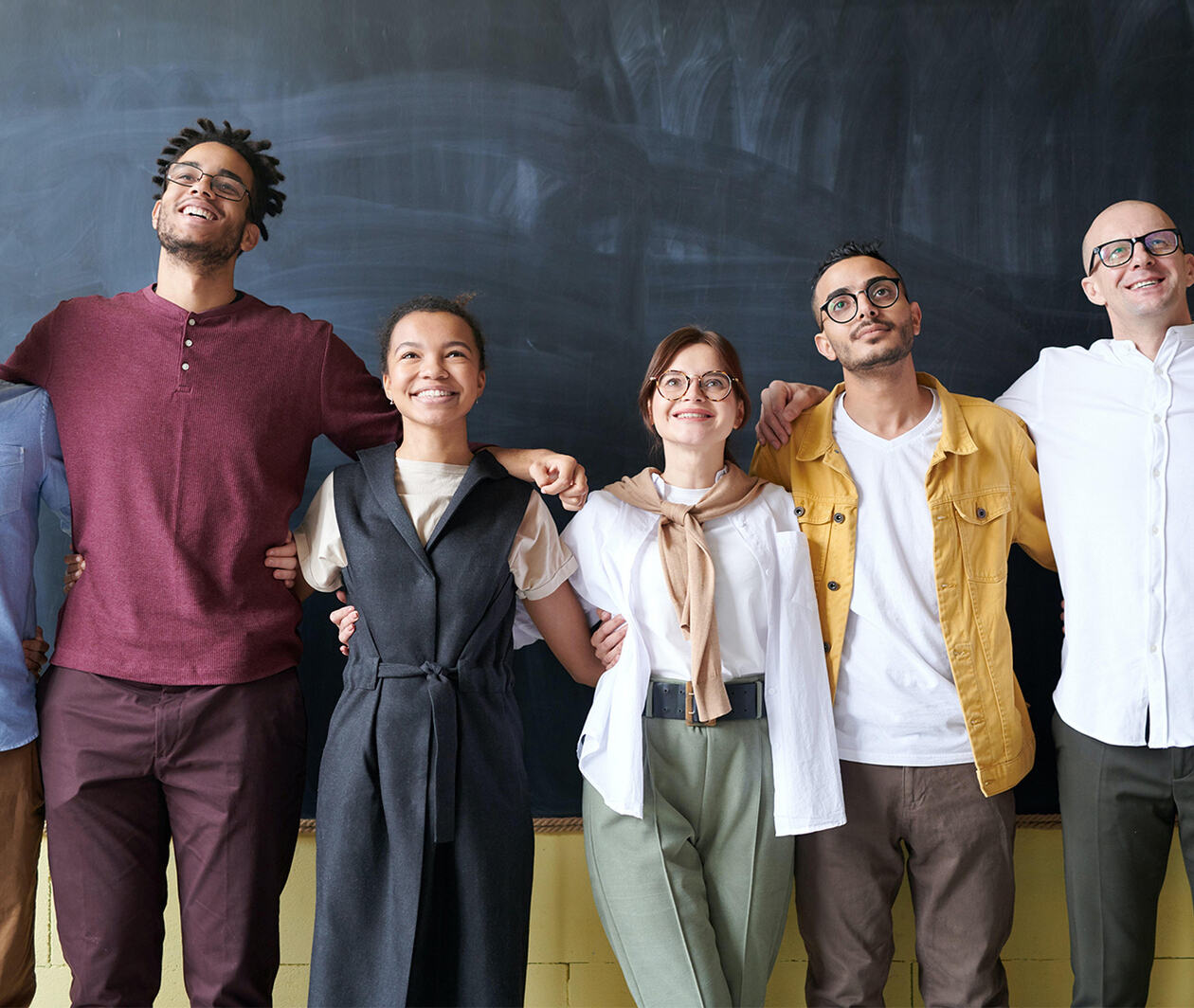 A group of talented colleagues standing in an office environment, feeling happy