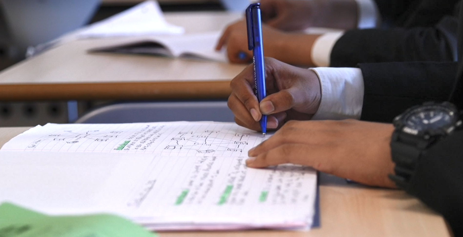 Pupil writing in his book