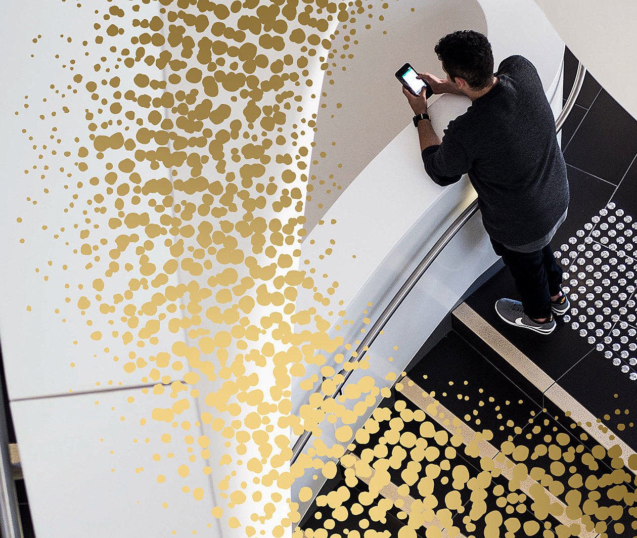 man on some spiral steps looking at a phone