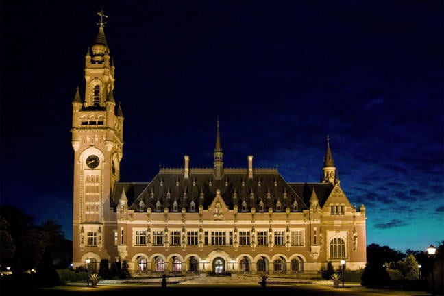 Photograph of the facade of the Peace Palace lit up at night time