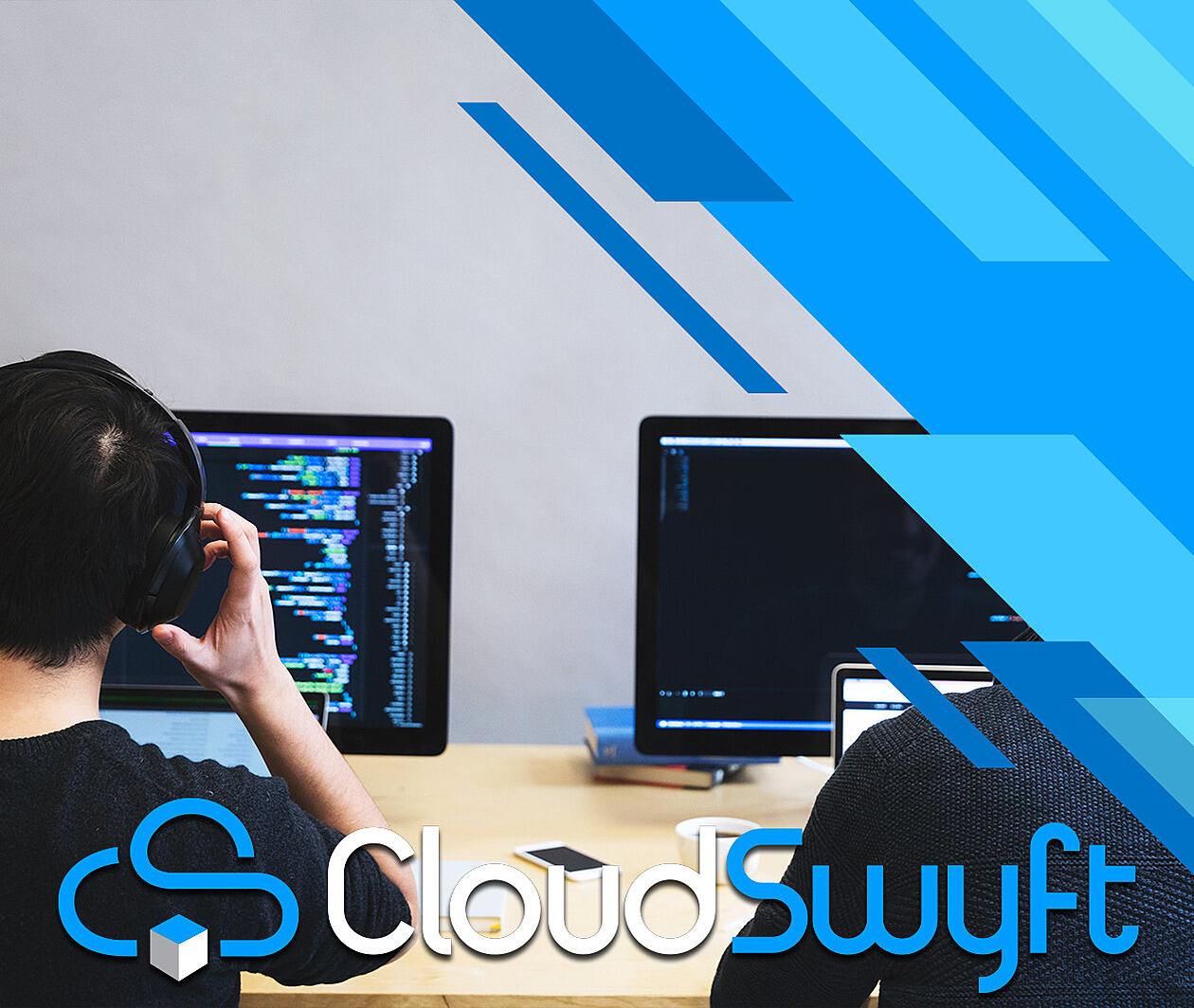 A man sitting with headphones in front of a computer. The image is labeled Cloudswyft.