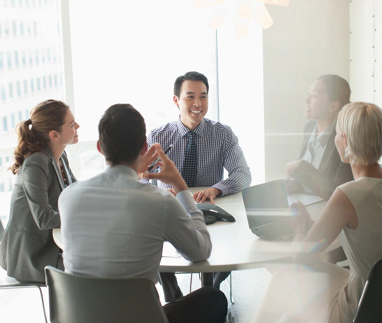 5 business people discussing on a round table in the office