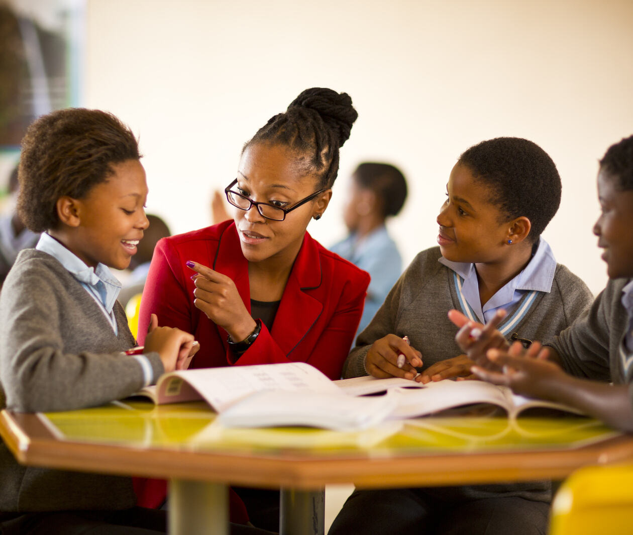 A teacher sitting with three children in a classroom