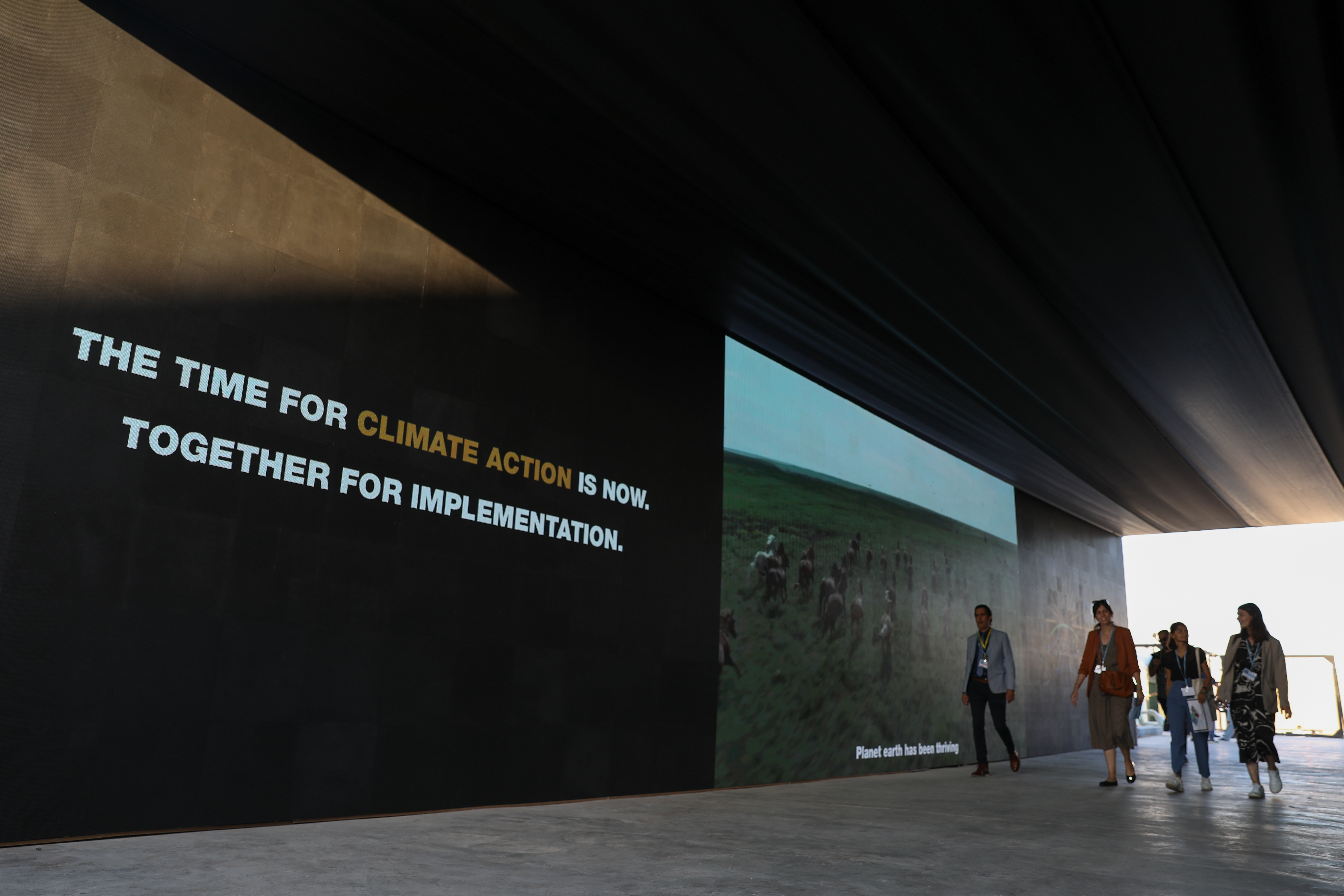 Words written on the side fo the COP27 venue saying 'The time for action is now. Together for implementation..