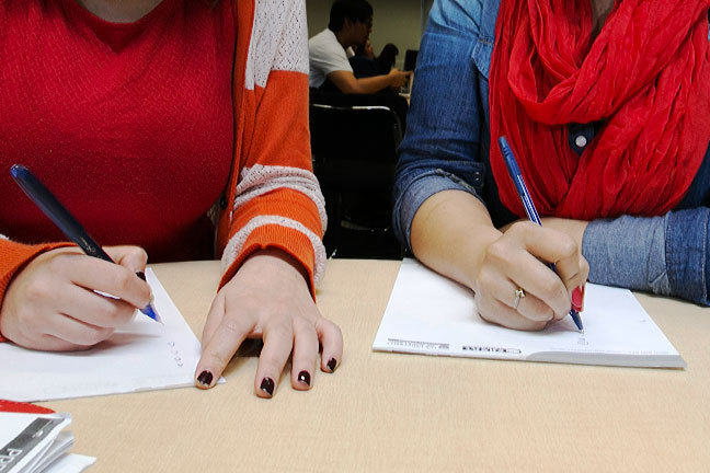 A pair of students glancing surreptitiously at each others' work