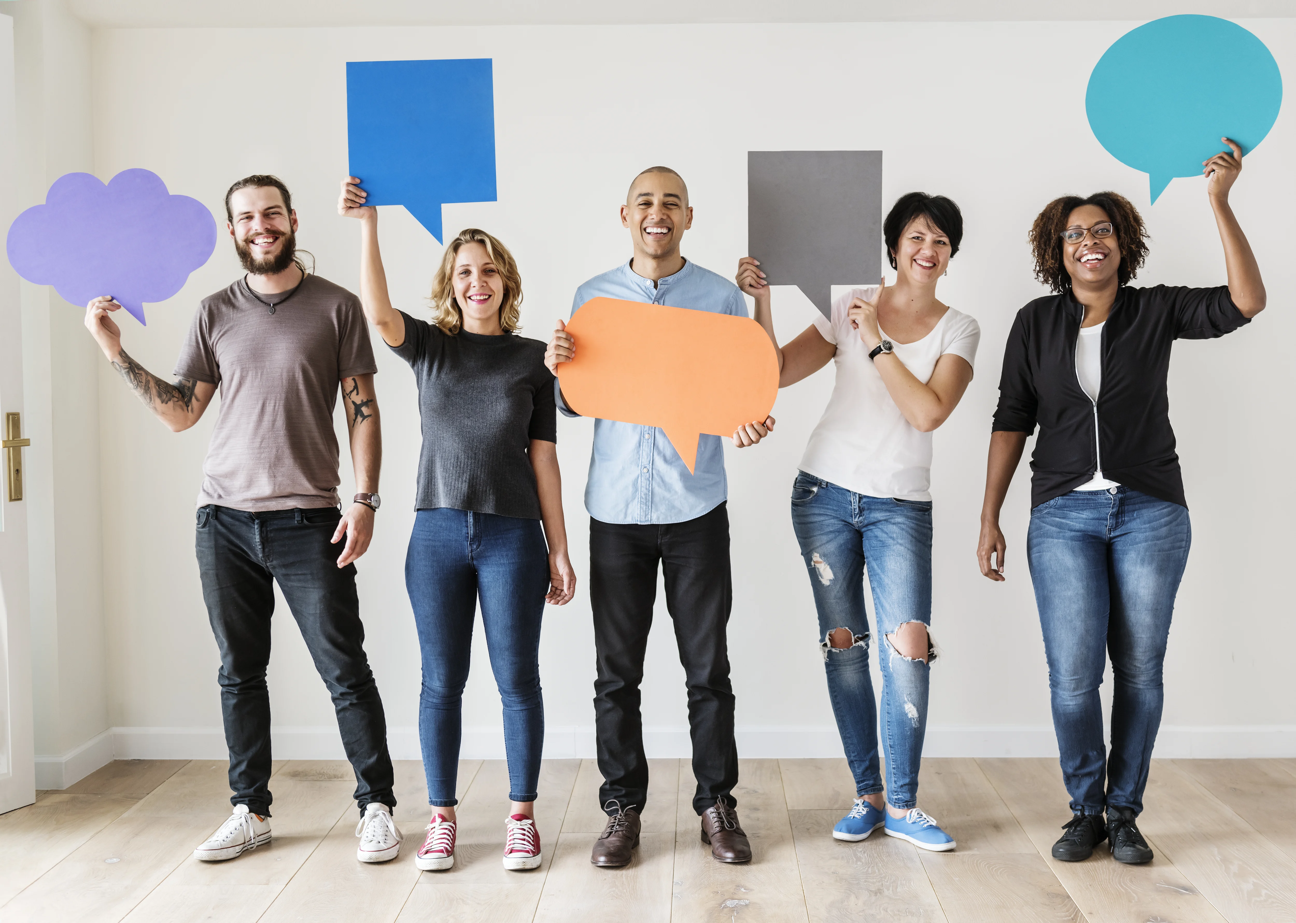 people carrying paper cutouts of speech bubbles