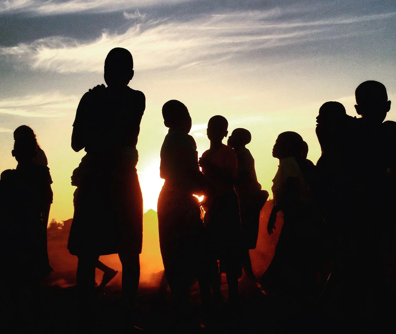 People standing in front of sunset