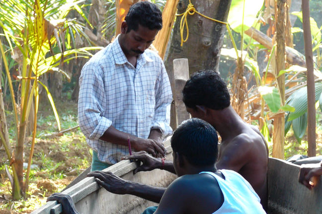 Two boat builders and an apprentice working on a tied or ‘stitched’ plank boat