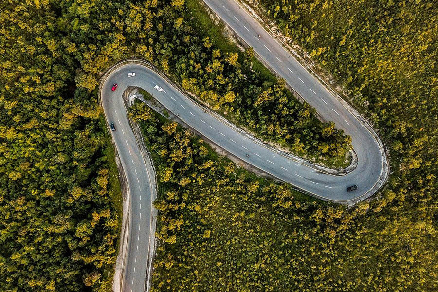 Aerial shot of a winding road through woodland