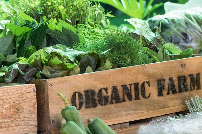 A wooden box, containing vegetables. On the side is written 'ORGANIC FARM@