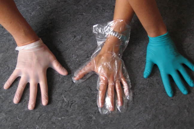 Three hands with different coloured gloves on