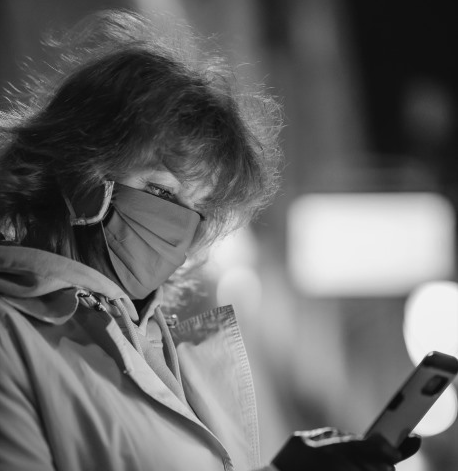 Woman in facemark looking at phone