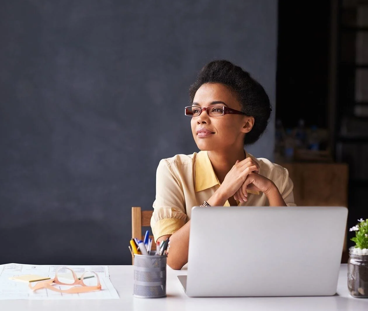 Woman sitting at work desk contemplating