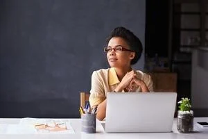 Woman sitting at work desk contemplating