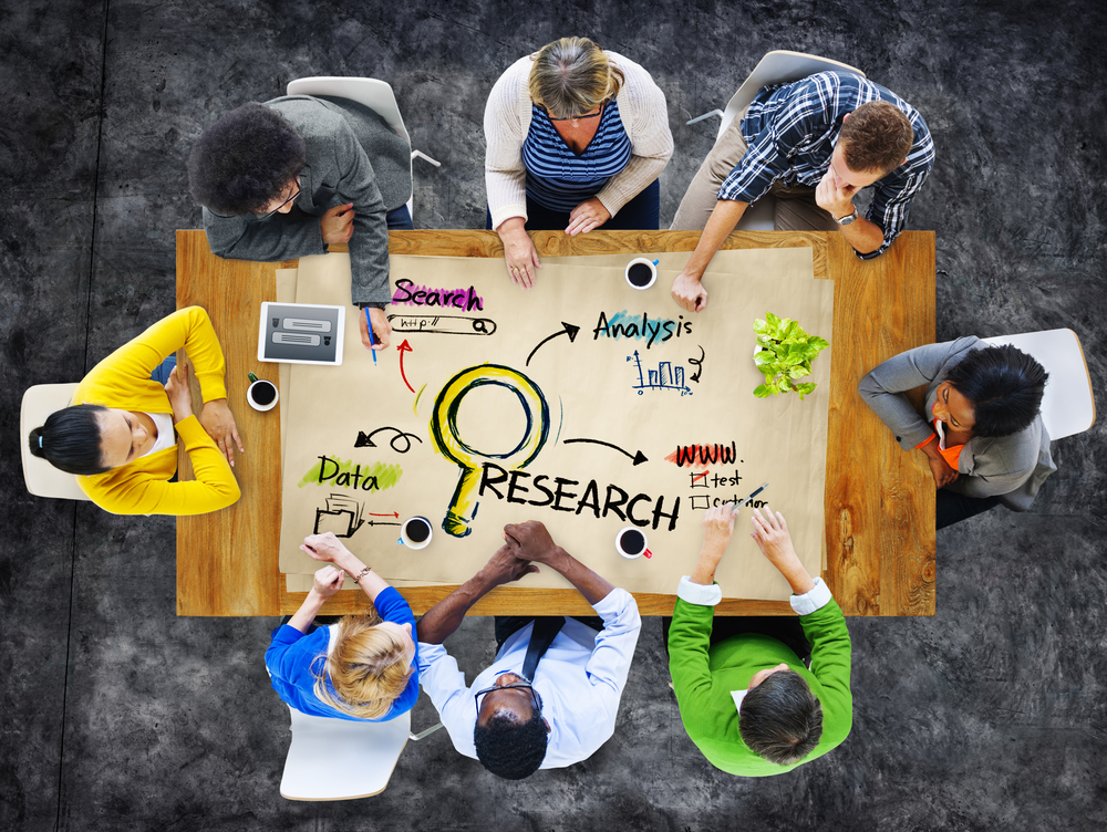 People sitting at a table planning and discussing research steps