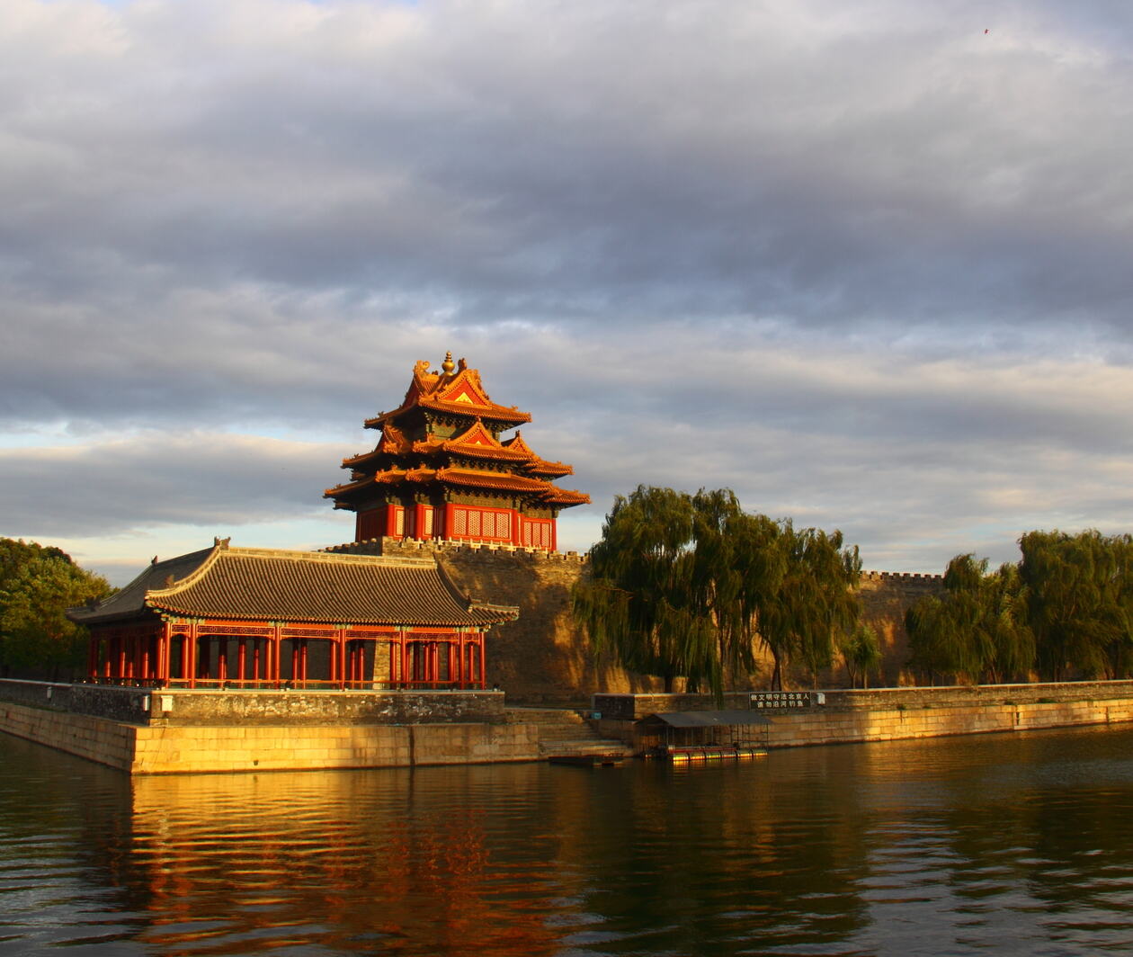 The Forbidden City corner tower during sunset with reflections on the moat.
