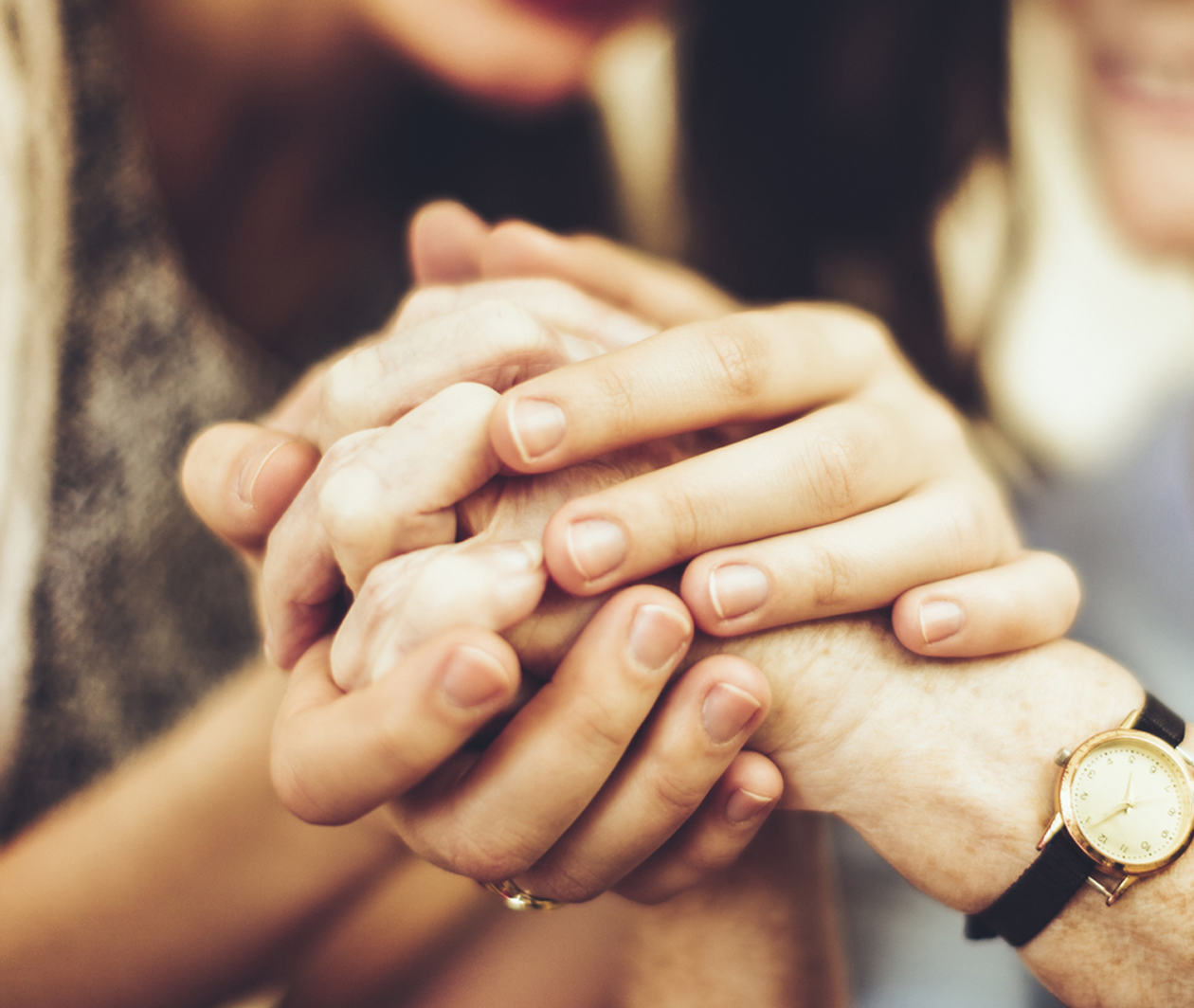 Image of young and old persons holding hands