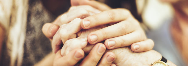 Image of young and old persons holding hands