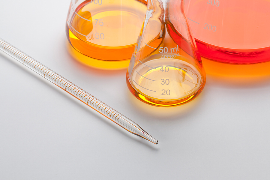 Calibrated pipette and flasks with orange liquid